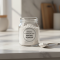 Glass jar of aluminium-free baking powder on white marble